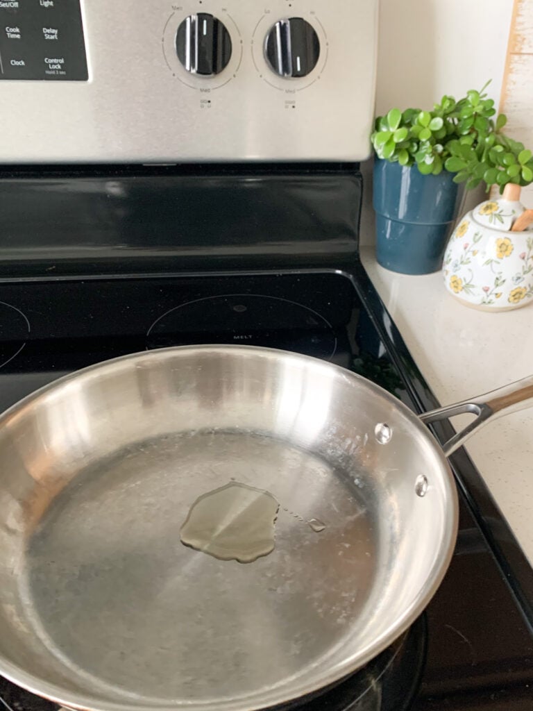 oil heating in pan for pan searing chicken