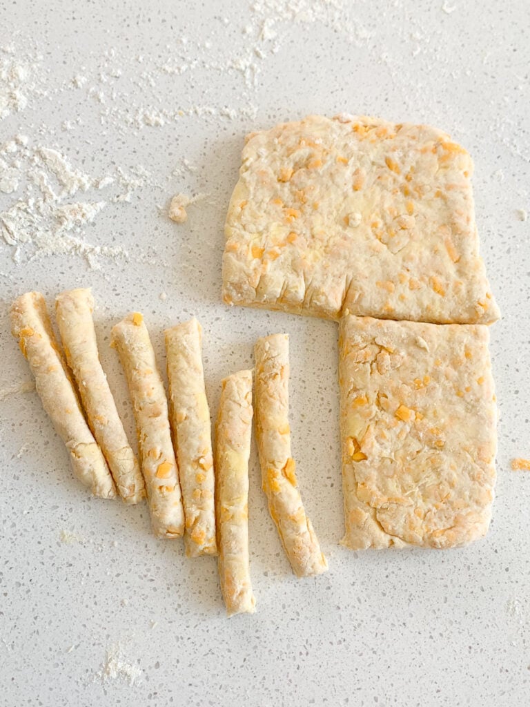 slicing cheese straw dough into strips