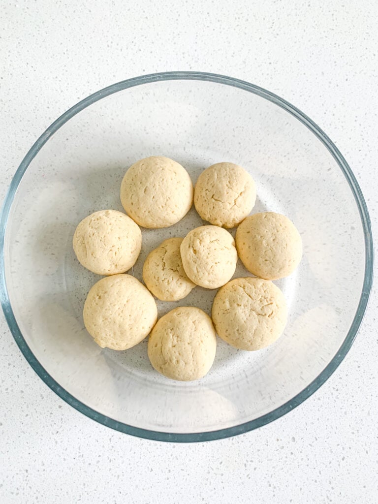 adding wafer cookies to bowl to start making banana pudding