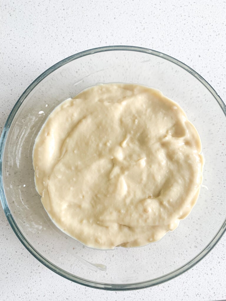 adding a layer of homemade pudding on top of bananas to make banana pudding