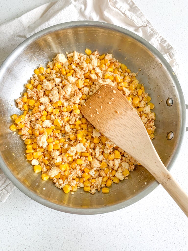 stirring ingredients together for Mexican street corn salad