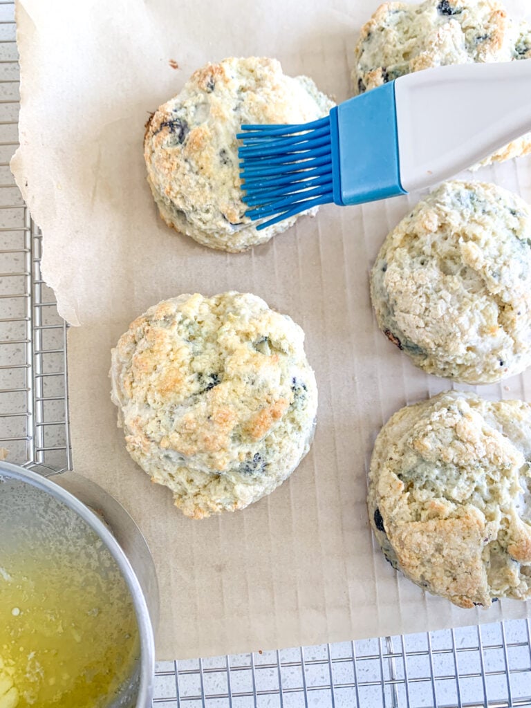 brushing blueberry biscuits with melted butter
