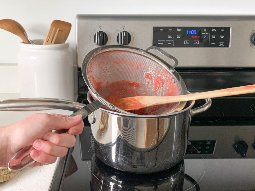straining seeds out of strawberry mixture before heating