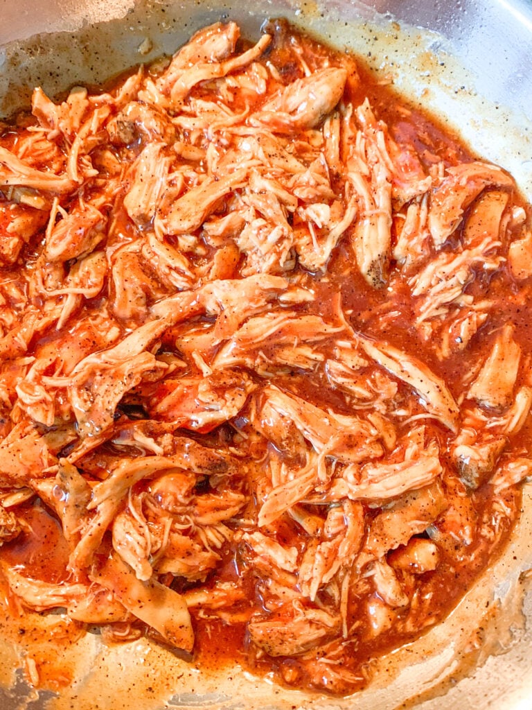 shredded chicken and bbq sauce heating in a pan