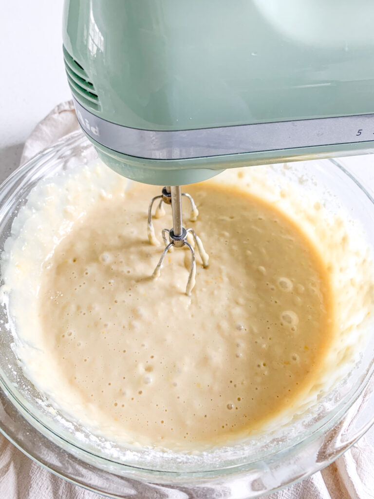 mixing sourdough lemon cake batter in a bowl