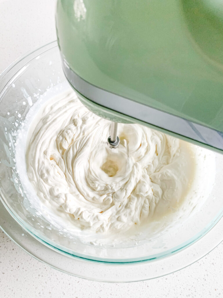 whipping whipped cream frosting in a bowl