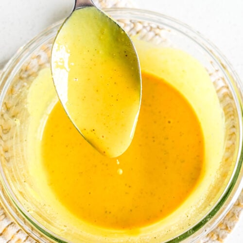 freshly made carolina gold bbq sauce being served on a spoon