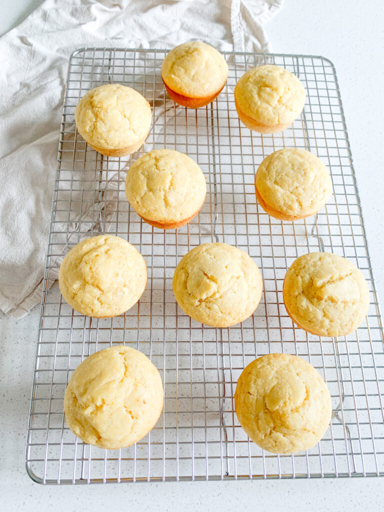 freshly baked sourdough corn muffins cooling on a cooling rack