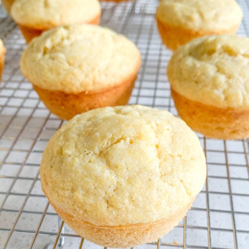 freshly baked sourdough corn muffins cooling on a cooling rack