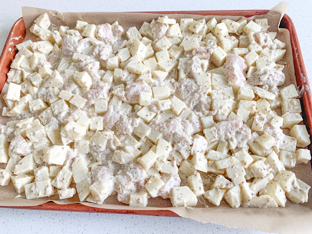 chicken and potatoes tossed in homemade sauce and ready to bake in the oven on a sheet pan