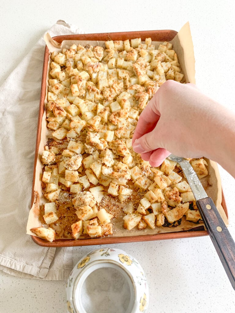 adding extra seasonings to sheet pan chicken and potatoes
