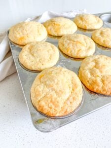 freshly baked sourdough cheddar cheese muffins in the baking tin