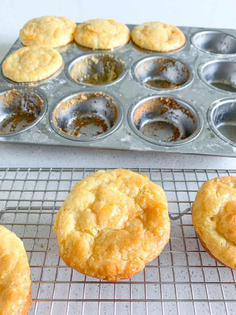 sourdough cheddar cheese muffins getting taken out of the tin