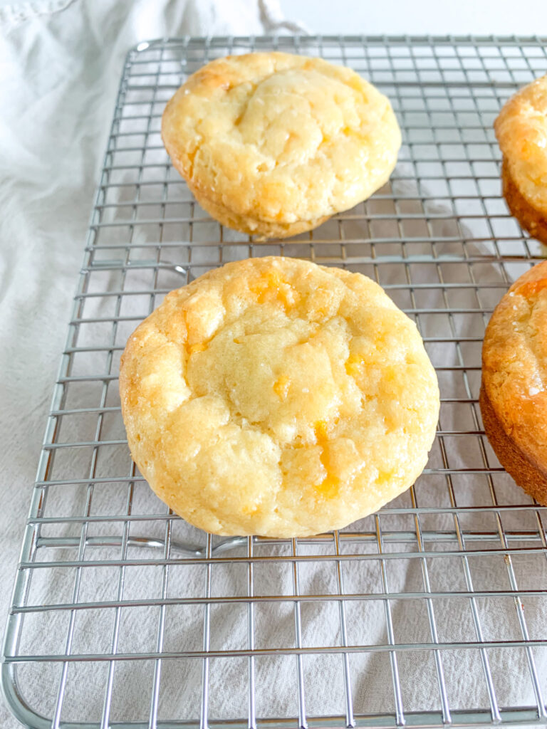 freshly baked sourdough cheddar cheese muffins on a wire rack