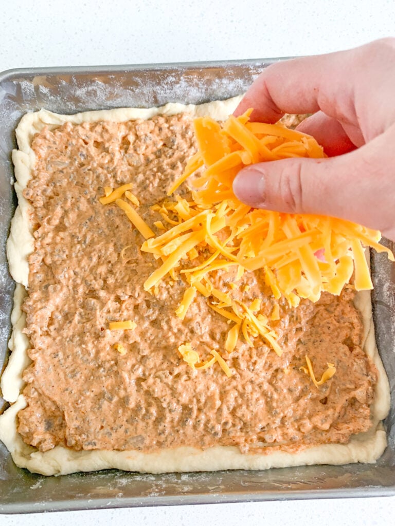 adding cheese on top of beef filling in crust