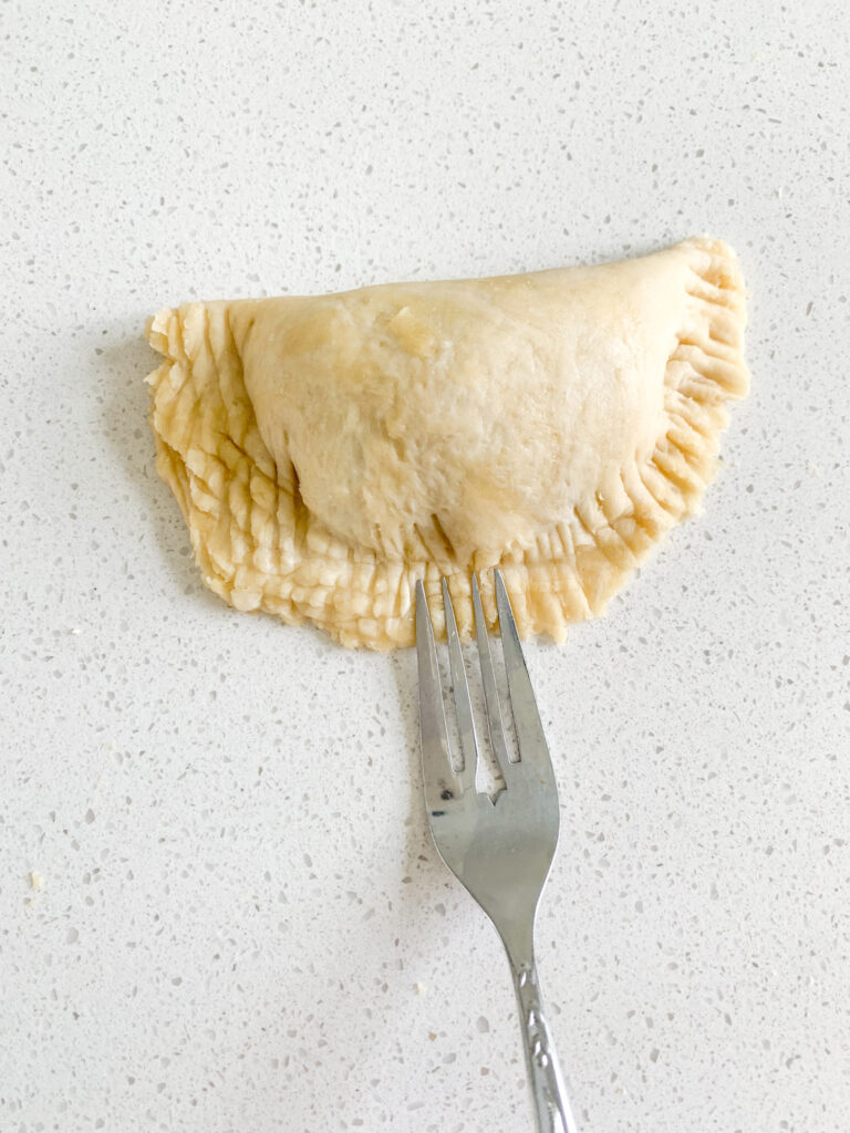 using a fork to crimp sourdough hand pie dough