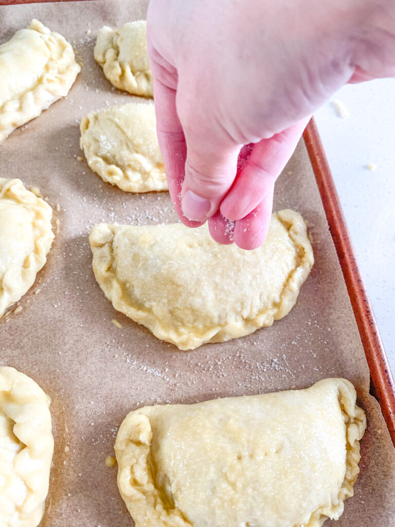 adding cane sugar on top of sourdough hand pies before baking