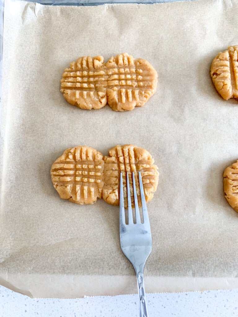 pressing sourdough peanut butter cookie dough with a fork