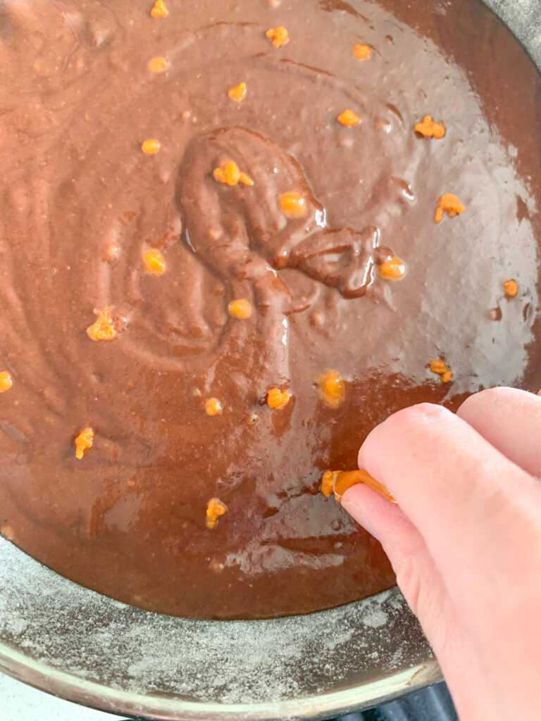 adding dots of pumpkin puree to top of brownie batter