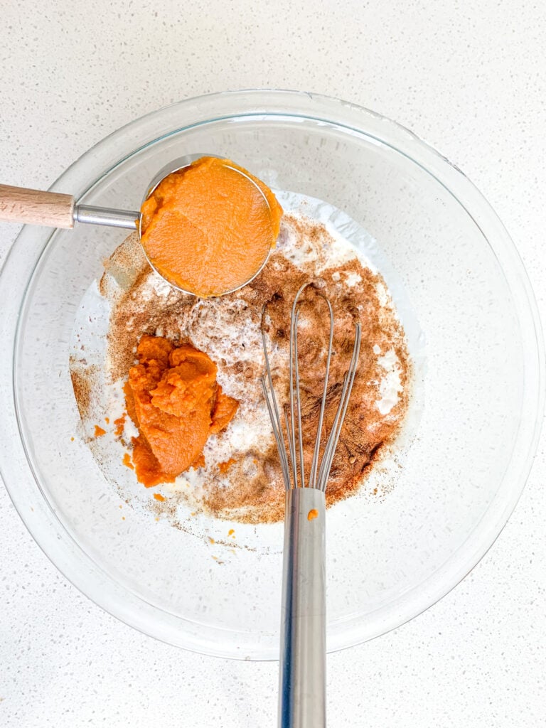 adding ingredients for pumpkin pancakes to a mixing bowl