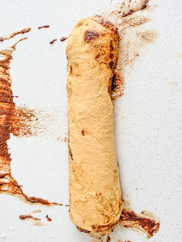 pumpkin cinnamon roll dough filled and rolled up