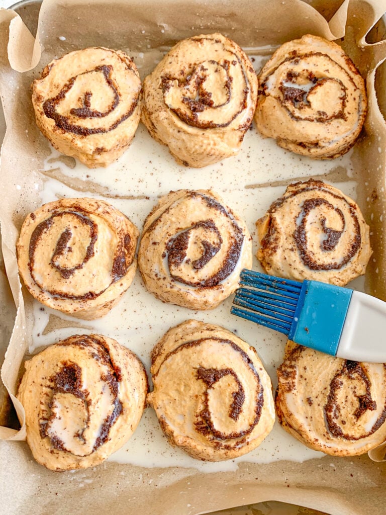 brushing unbaked cinnamon rolls with milk before baking