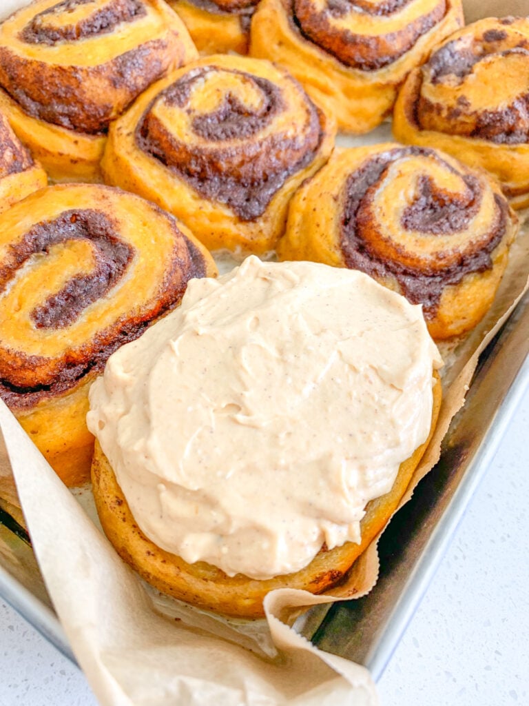 freshly baked and frosted sourdough pumpkin cinnamon rolls