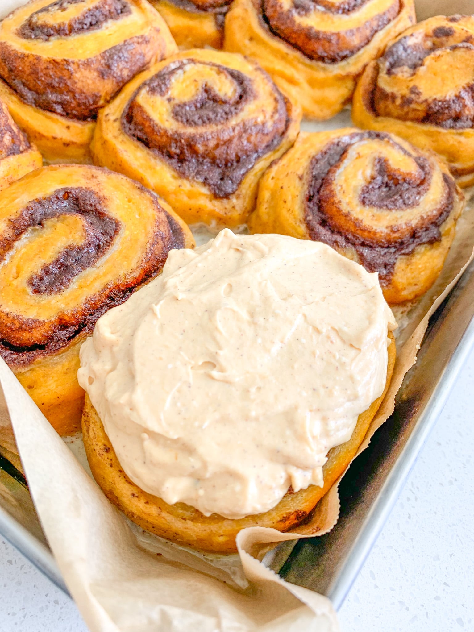 freshly baked and frosted sourdough pumpkin cinnamon rolls