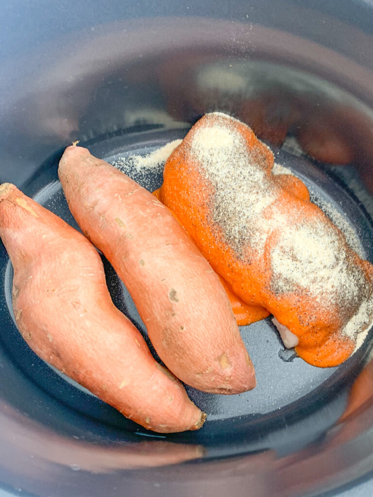 buffalo sauce and seasoning added to chicken in slow cooker